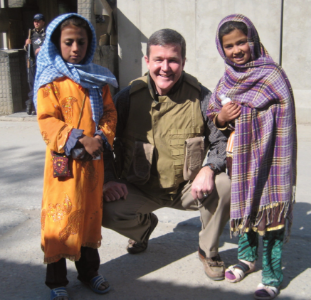 Warner with two young girls touring his compound