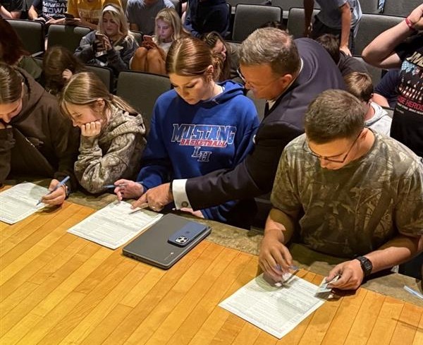 Secretary Warner explaining the voter registration form to ﻿students at a recent Voter Registration Drive
