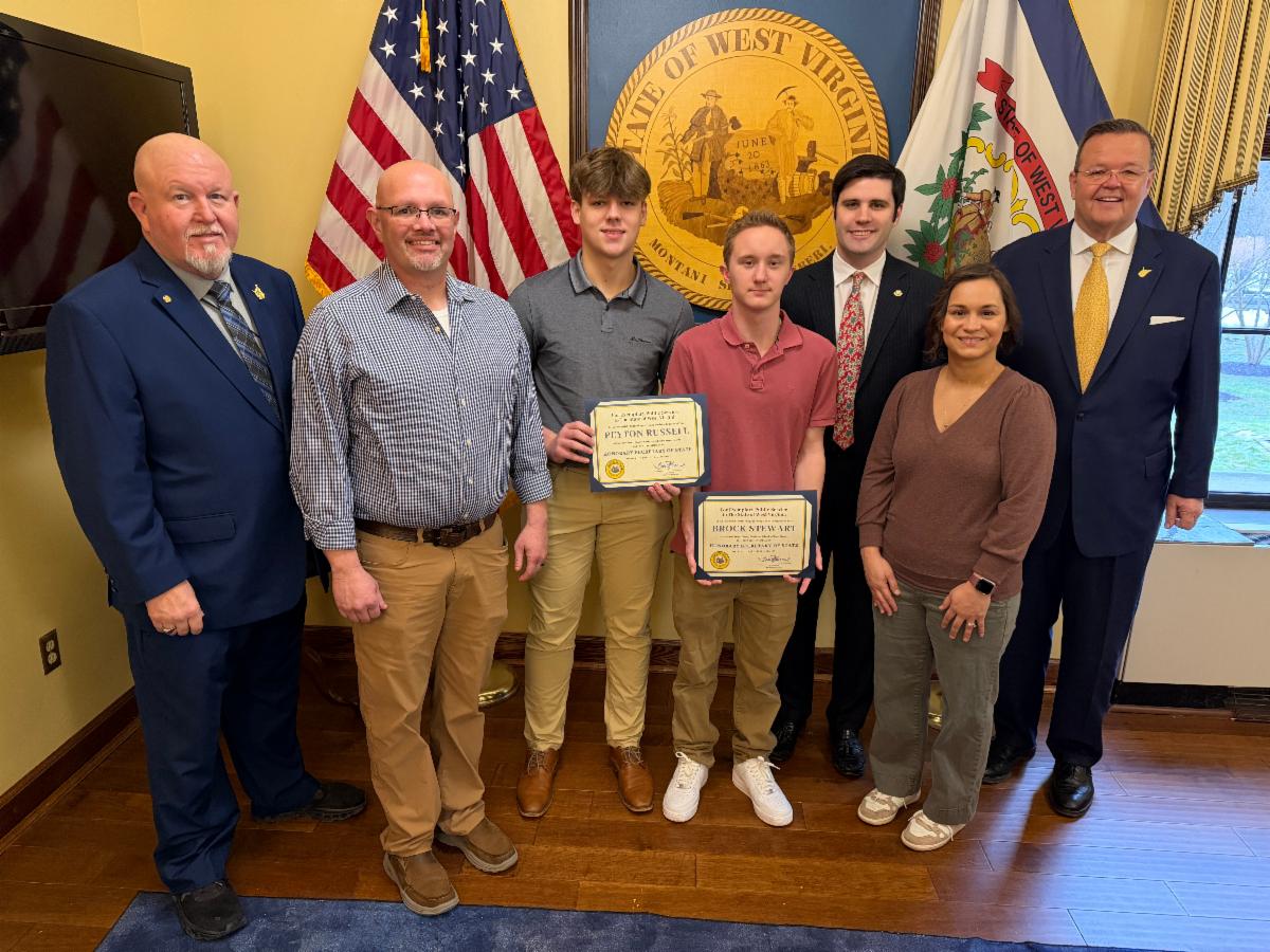 Group photo at the State Capitol featuring Delegate Scot C. Heckert, WCCS Executive Director Shane Hostutler, Honorary Secretary of State Peyton Russell, Honorary Secretary of State Brock Stewart, Senator Trenton Barnhart, WCCS Lead Teacher Naddine Border, and WV Secretary of State Kris Warner.