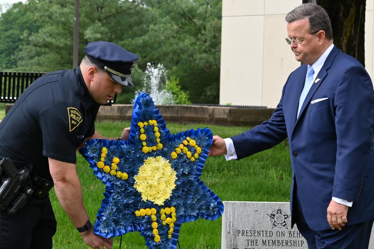 Detective R.S. Black of the Vienna Police Department and WV Secretary of State Kris Warner laying a memorial wreath