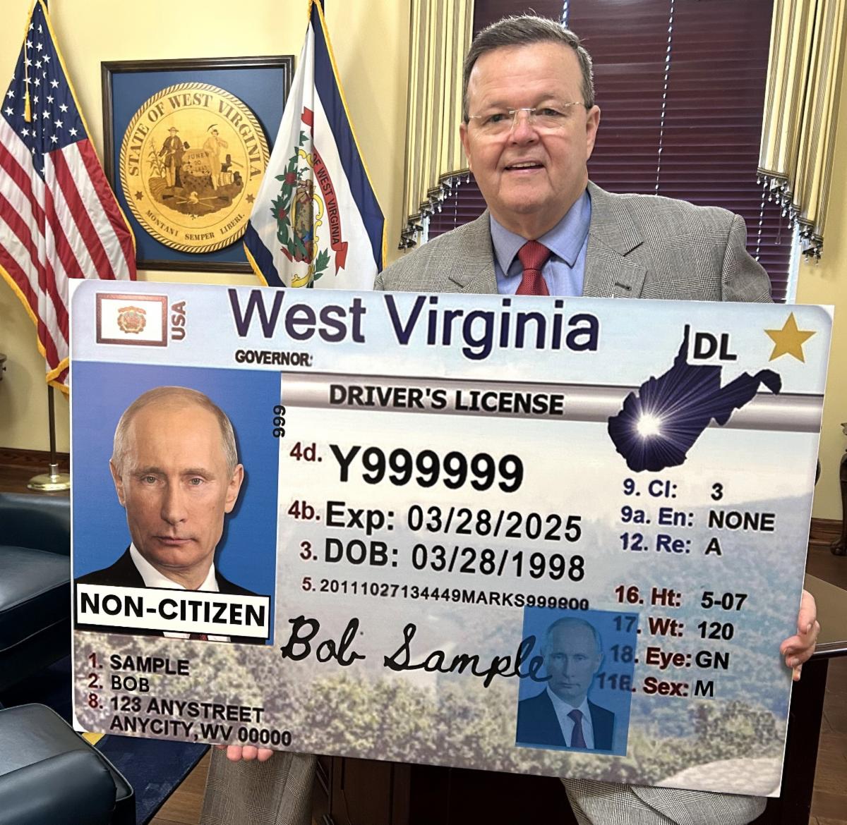 WV Secretary of State Kris Warner holding a sample driver's license depicting HB 3016 citizenship designation